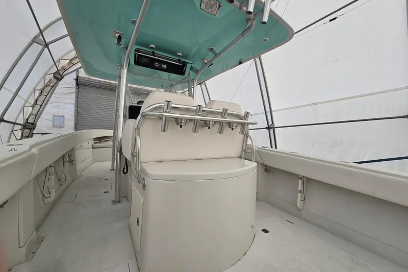 Slide: The Image of 2010 Jupiter 34 FS boat interior with seating and rod holders in a covered area. - 15