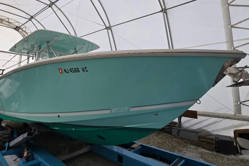 Slide: The Image of 2010 Jupiter 34 FS boat in storage, light blue hull, under a protective canopy. - 2