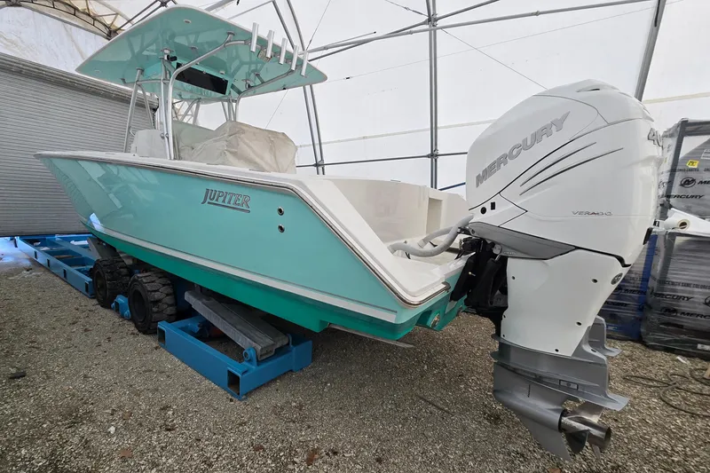 Slide: The Image of 2010 Jupiter 34 FS boat with Mercury engine in storage, turquoise hull, covered interior. - 5