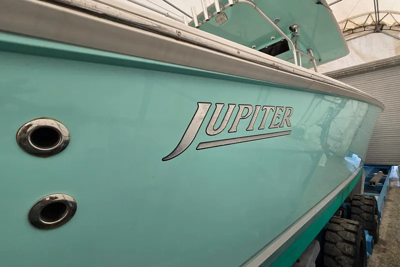 Slide: The Image of 2010 Jupiter 34 FS boat in storage, showcasing sleek turquoise hull design. - 8
