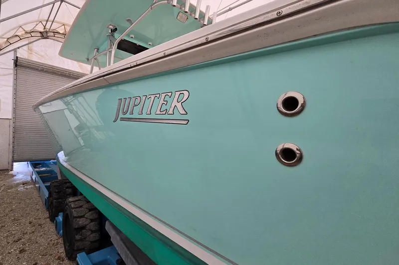 Slide: The Image of 2010 Jupiter 34 FS boat in storage, showcasing sleek turquoise hull design. - 9