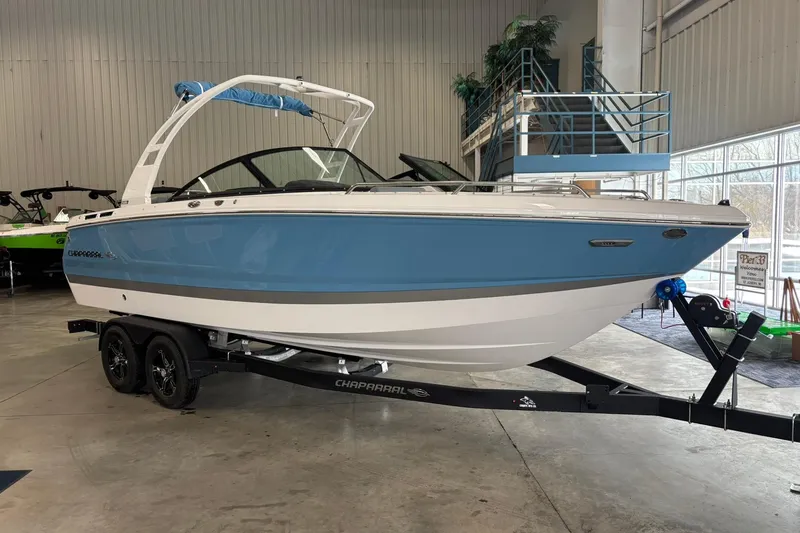 The Image of 2026 Chaparral SSX 4 boat in showroom, blue and white design on trailer. - 1