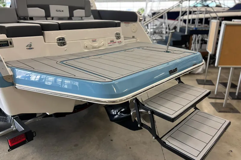 Slide: The Image of 2026 Chaparral SSX 4 boat with swim platform and foldable steps in showroom. - 10