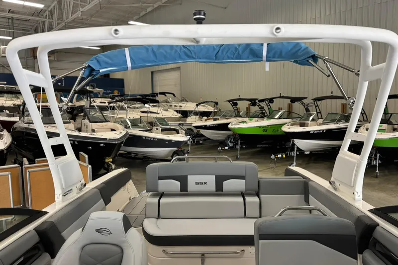 Slide: The Image of 2026 Chaparral SSX 4 boat interior in showroom with multiple boats in background. - 25