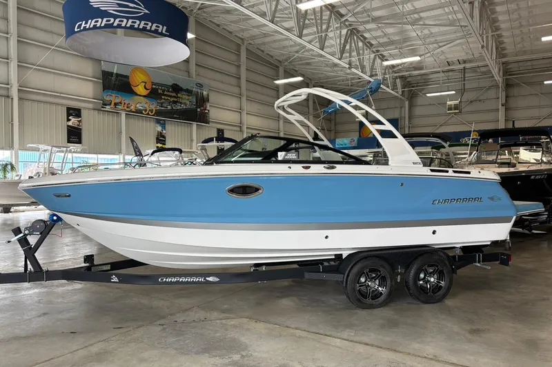 Slide: The Image of 2026 Chaparral SSX 4 boat in showroom, blue and white design on trailer. - 3