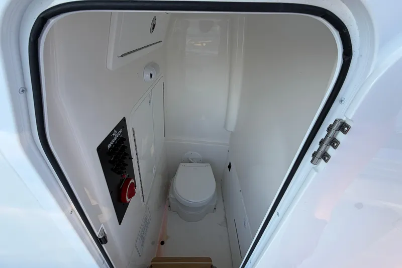 Slide: The Image of 2024 Regulator 26XO boat interior with compact marine toilet. - 10
