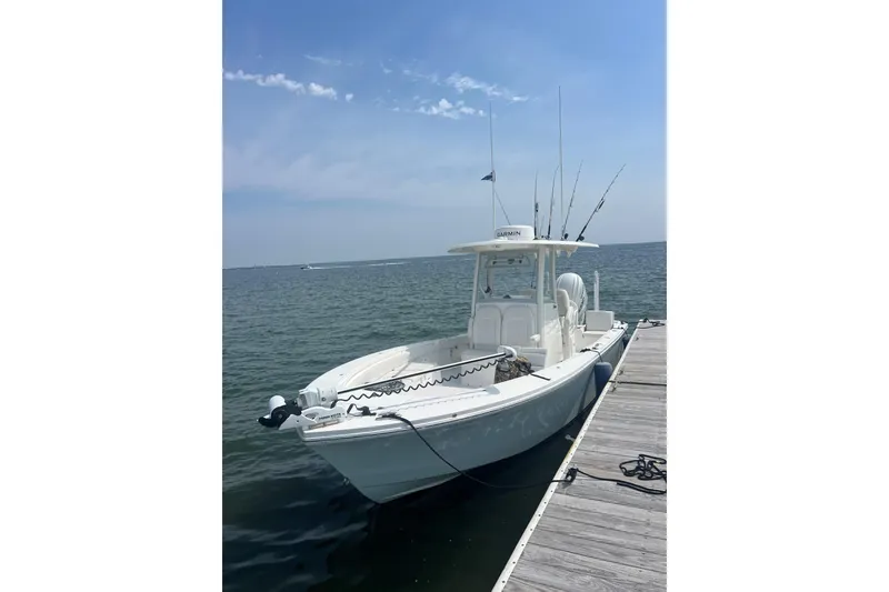 Slide: The Image of 2024 Regulator 26XO boat docked by the water on a sunny day. - 3