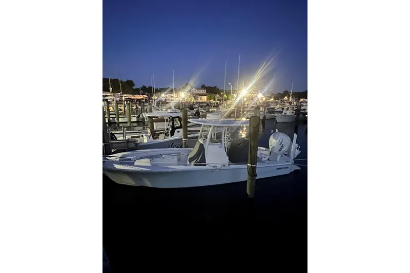 Slide: The Image of 2024 Regulator 26XO boat docked at night, illuminated marina background. - 5