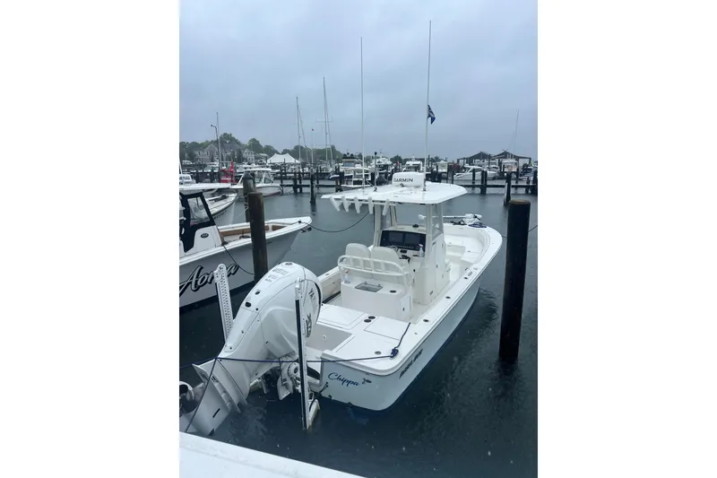 Slide: The Image of 2024 Regulator 26XO boat docked in a marina on a cloudy day. - 7