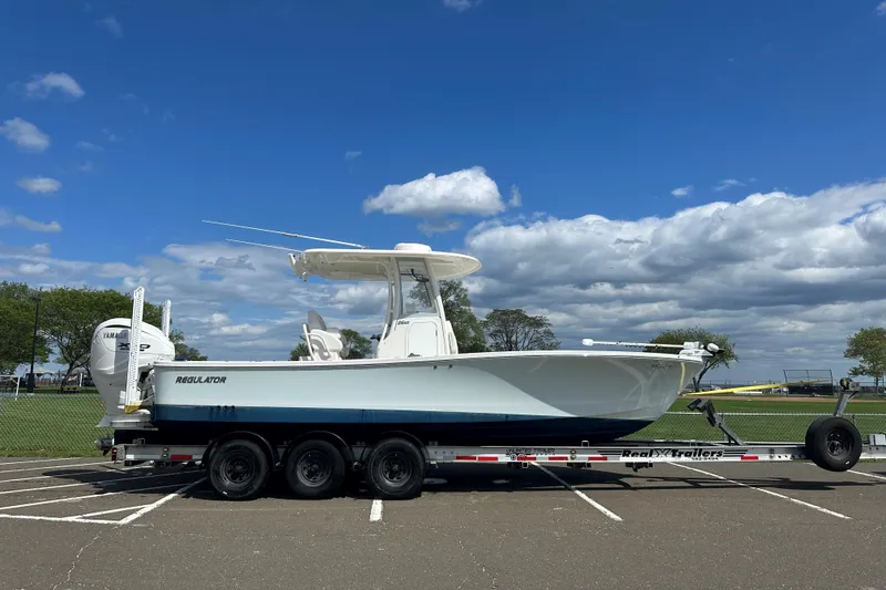 Slide: The Image of 2024 Regulator 26XO boat on trailer under blue sky with clouds. - 8