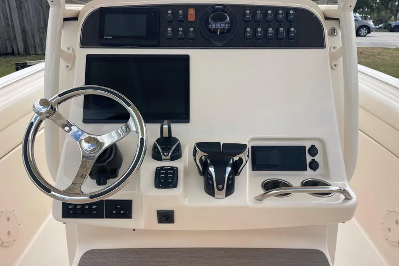 Slide: The Image of 2021 Grady-White Canyon 271 helm with steering wheel, controls, and display screens. - 10