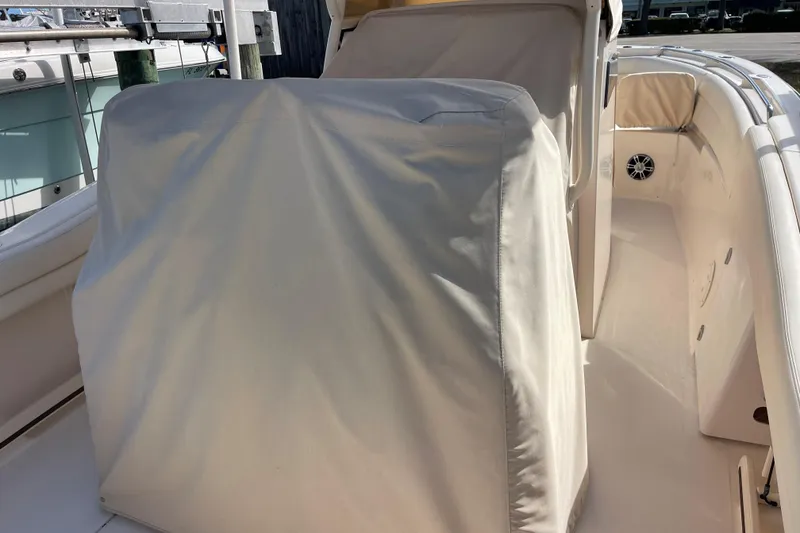Slide: The Image of 2021 Grady-White Canyon 271 boat interior with protective covers and seating area. - 18