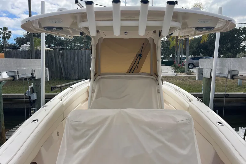 Slide: The Image of 2021 Grady-White Canyon 271 boat docked, featuring covered seating and rod holders. - 19