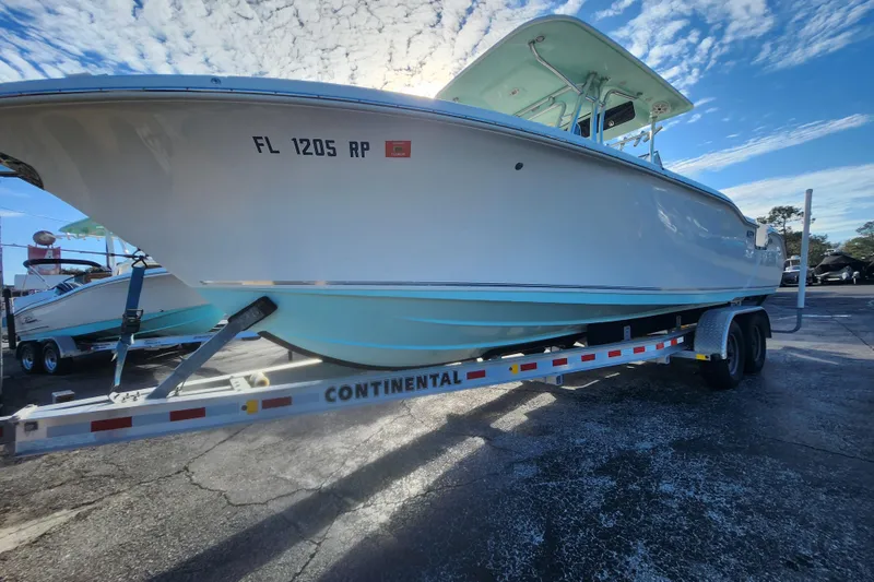 Slide: The Image of 2018 Key West 263 FS boat on trailer under a blue sky. - 12
