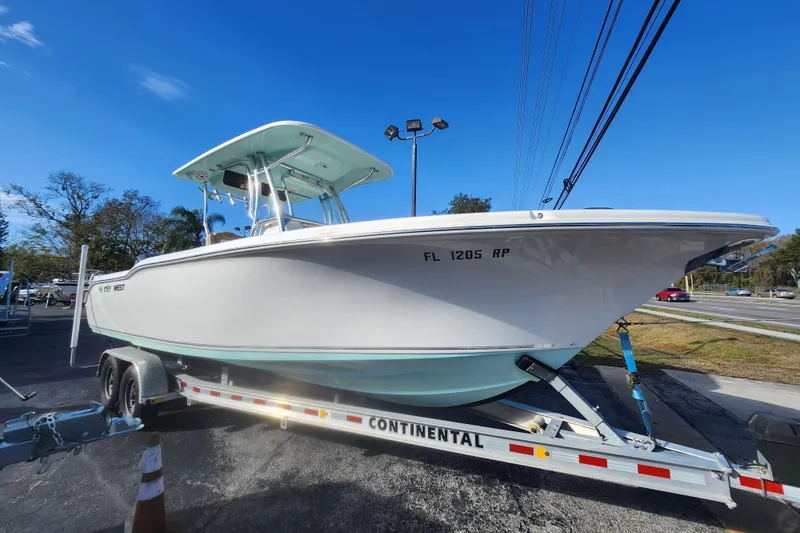 Slide: The Image of 2018 Key West 263 FS boat on trailer under clear blue sky. - 13
