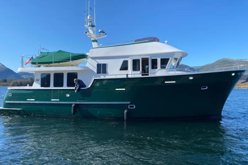 The Image of 2003 Northern Marine 57 Raised Pilothouse yacht on water with mountains in background. - 0
