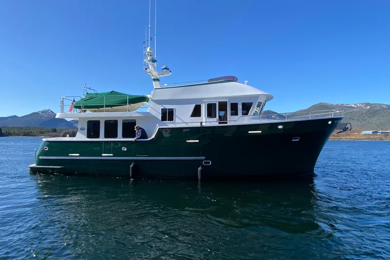 Slide: The Image of 2003 Northern Marine 57 Raised Pilothouse yacht on scenic water with mountains. - 2