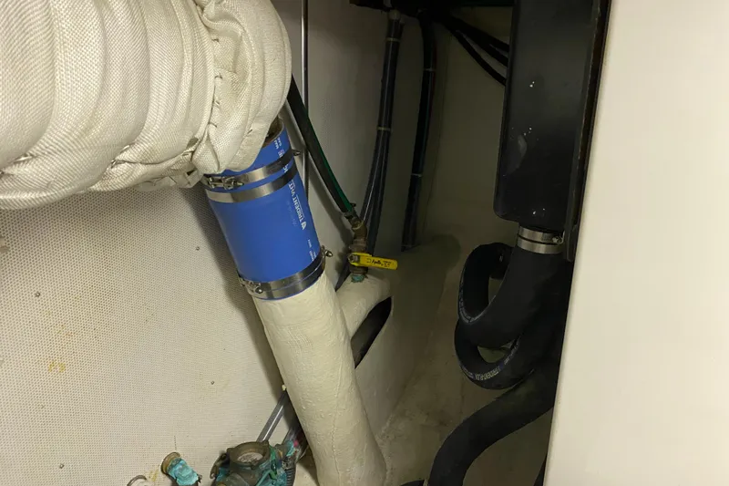 Slide: The Image of Engine room of 2003 Northern Marine 57 Raised Pilothouse with visible piping and hoses. - 29