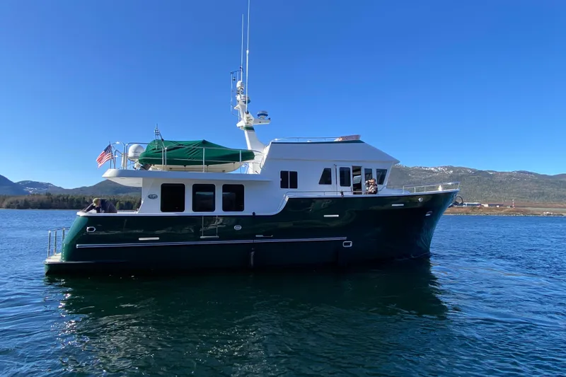 Slide: The Image of 2003 Northern Marine 57 Raised Pilothouse yacht on calm water, scenic mountain backdrop. - 3