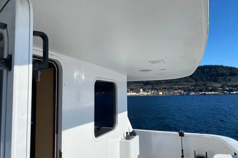 Slide: The Image of 2003 Northern Marine 57 Raised Pilothouse yacht, docked with scenic waterfront view. - 33