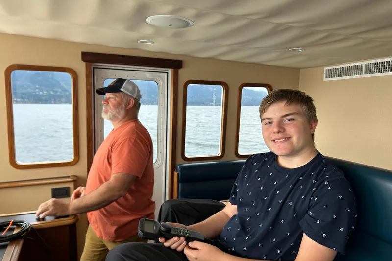 Slide: The Image of Two people inside a 2004 Northern Marine 57 Raised Pilothouse, enjoying a scenic boat ride. - 35