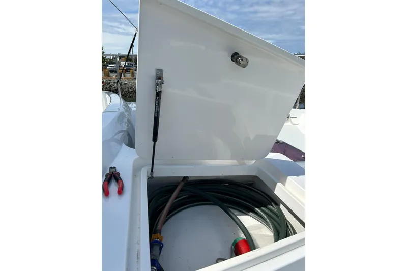 Slide: The Image of Open storage compartment on 2004 Northern Marine 57 Raised Pilothouse with tools and hose. - 41
