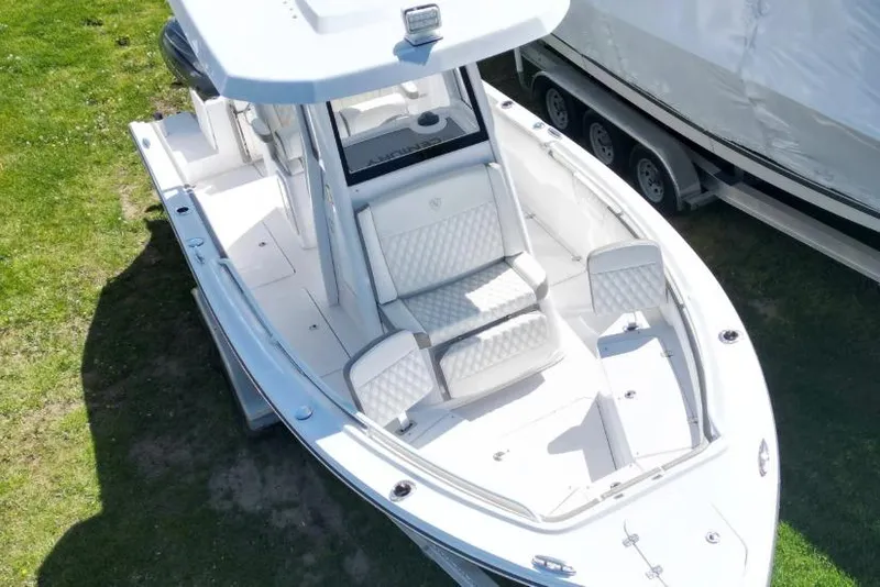 Slide: The Image of 2022 Century 2400 Center Console boat on grass, featuring sleek white design and spacious seating. - 16