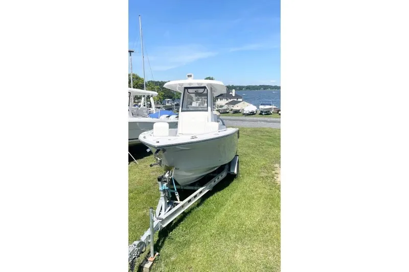 Slide: The Image of 2022 Century 2400 Center Console boat on trailer by a lakeside. - 4