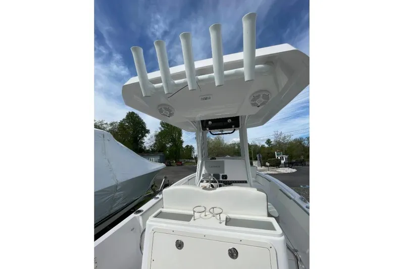 Slide: The Image of 2022 Century 2400 Center Console boat with rod holders and steering console under blue sky. - 5