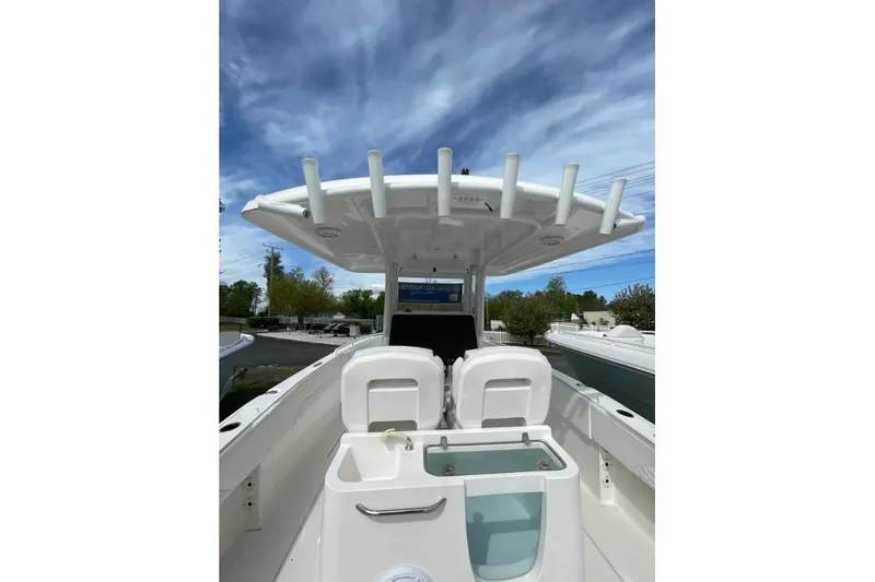 Slide: The Image of 2022 Century 2400 Center Console boat with seating and rod holders under a blue sky. - 6