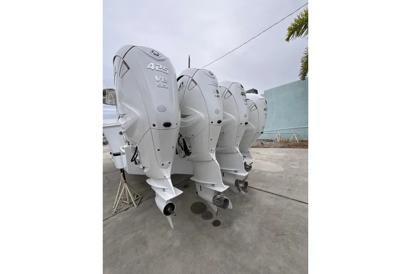 Slide: The Image of 2023 Regulator 41 boat with triple 425 V8 outboard engines, parked on concrete. - 4