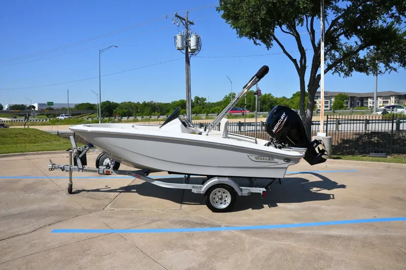 Slide: The Image of 2026 Boston Whaler 130 Super Sport on a trailer, parked in a lot. - 0
