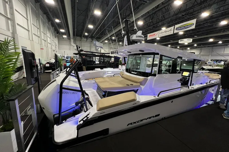 The Image of 2026 Axopar 29 XC Cross Cabin boat displayed at an indoor exhibition. - 0