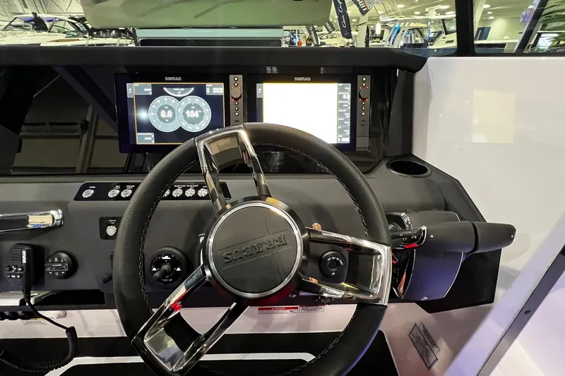 Slide: The Image of 2026 Axopar 29 XC Cross Cabin dashboard with steering wheel and dual Simrad displays. - 17