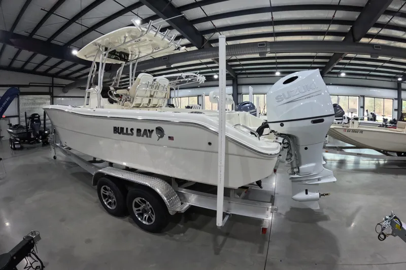 The Image of 2026 Bulls Bay 255 Center Console boat with Suzuki engine on trailer in showroom. - 1
