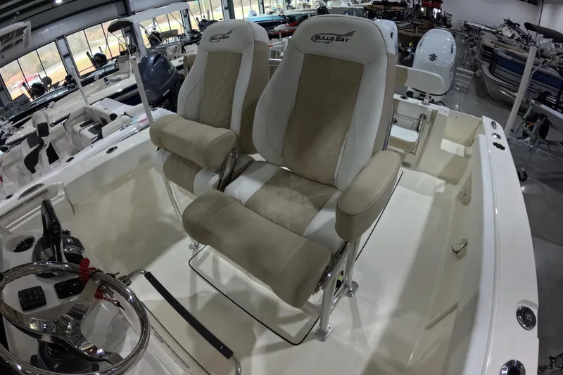 Slide: The Image of 2026 Bulls Bay 255 Center Console boat interior with dual seats and steering wheel. - 13