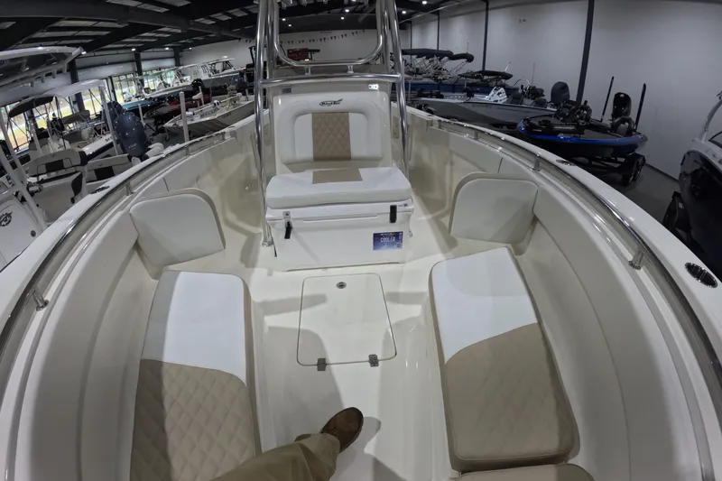 Slide: The Image of 2026 Bulls Bay 255 Center Console boat interior with cushioned seating in a showroom. - 20