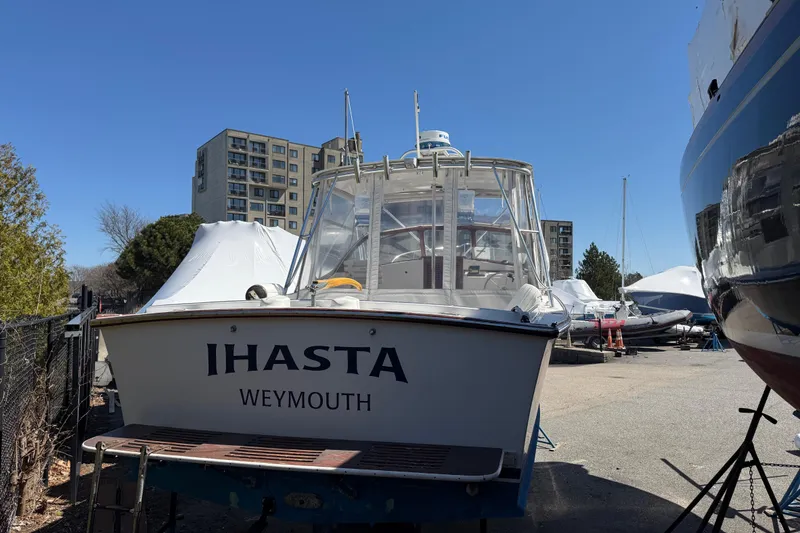 Slide: The Image of 2007 Fortier Express Cruiser docked in Weymouth, surrounded by other boats and buildings. - 2