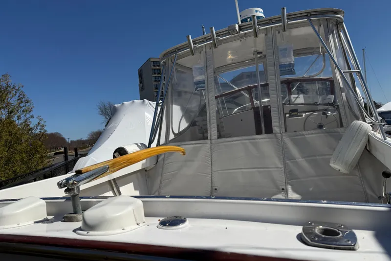 Slide: The Image of 2007 Fortier Express Cruiser boat with enclosed cockpit, docked under clear blue sky. - 3
