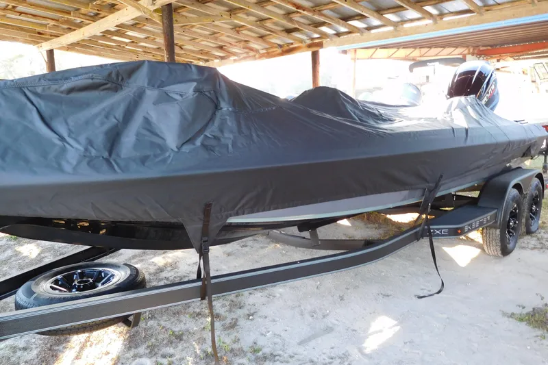 The Image of 2026 Skeeter ZXE21 boat covered, parked under a shelter, on a trailer. - 1