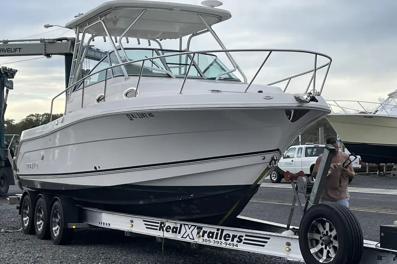 Slide: The Image of 2014 Robalo R305 Walkaround boat with dual Yamaha engines on water. - 1