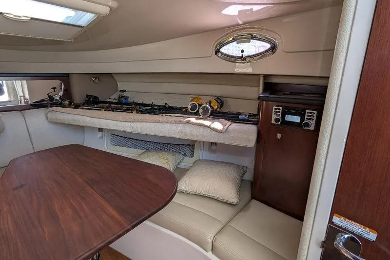 Slide: The Image of 2014 Robalo R305 Walkaround cabin interior with fishing rods and seating area. - 30