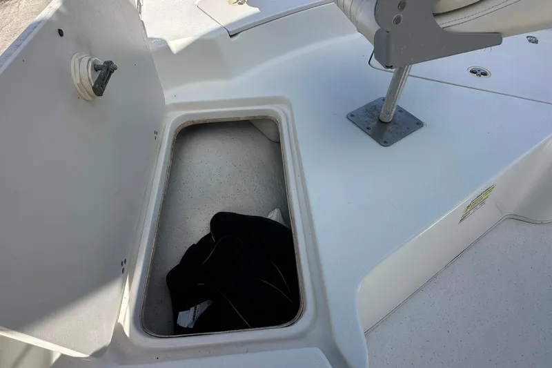 Slide: The Image of 2017 Carolina Skiff 198 DLV boat storage compartment with open lid and seat base. - 13