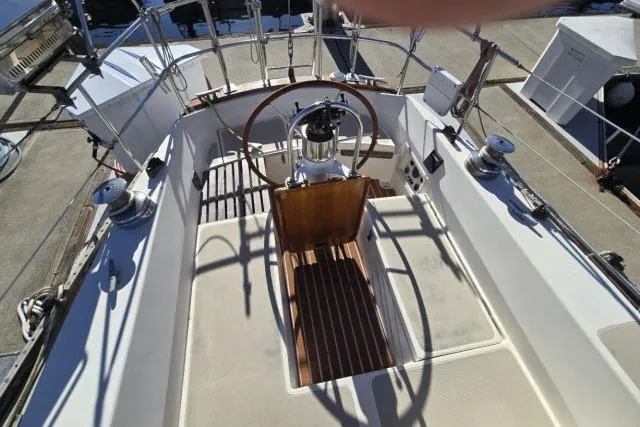 Slide: The Image of 1980 CAL 39 sailboat cockpit with wooden steering wheel and deck details. - 10
