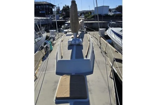 Slide: The Image of 1980 CAL 39 sailboat docked, view of deck and mast, surrounded by other boats. - 14