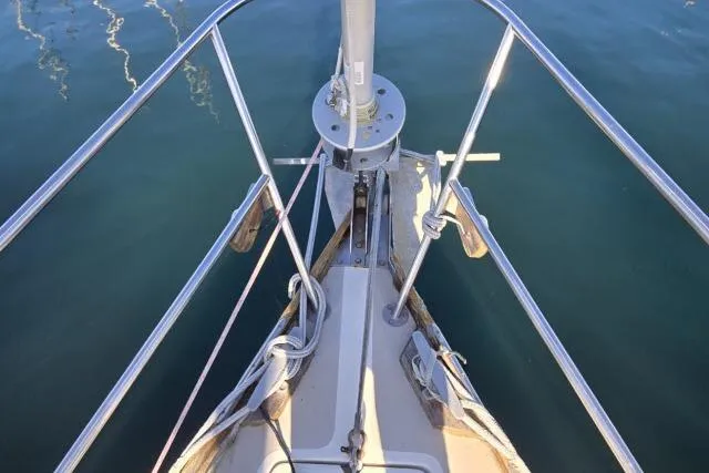 Slide: The Image of Bow of 1980 CAL 39 sailboat with stainless steel railings and calm water. - 15