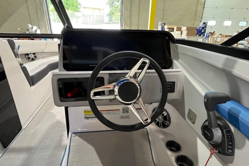 Slide: The Image of 2024 Regal LS4 Surf boat dashboard with steering wheel and control panel. - 10