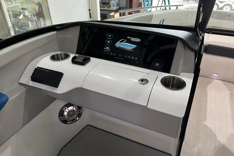 Slide: The Image of 2024 Regal LS4 Surf boat dashboard with touchscreen, cup holders, and speaker. - 13