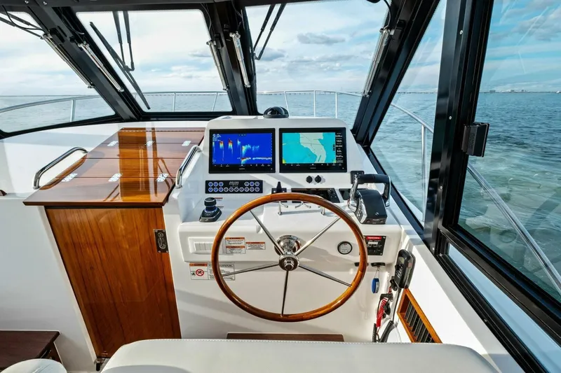 Slide: The Image of Helm of 2025 MJM 42 boat with navigation screens and wooden steering wheel. - 13