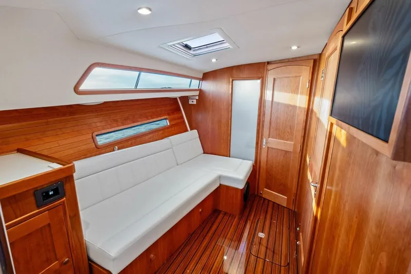 Slide: The Image of Luxurious 2025 MJM 42 yacht interior with wooden finish and white seating. - 16